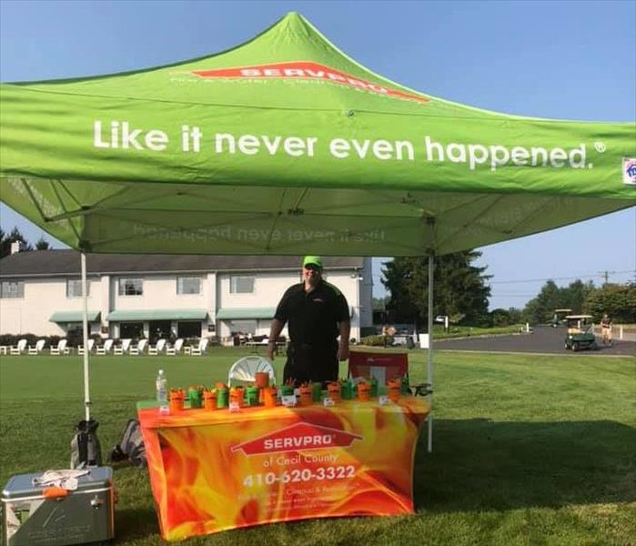 SERVPRO Sales Rep in front of Marketing table at golf event
